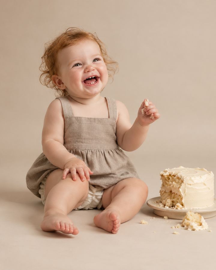 Cake Smash: laughing beside smashed cake